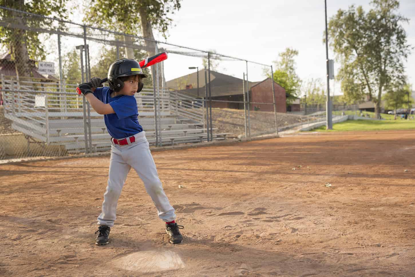 An image of a Boy batting at practice on the baseball field.