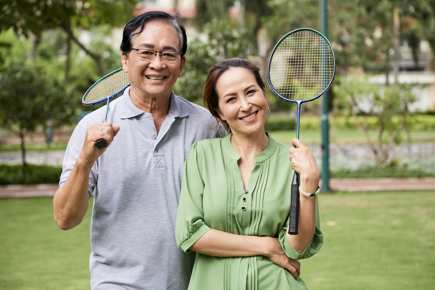 An image of a middle-aged badminton players in the park.