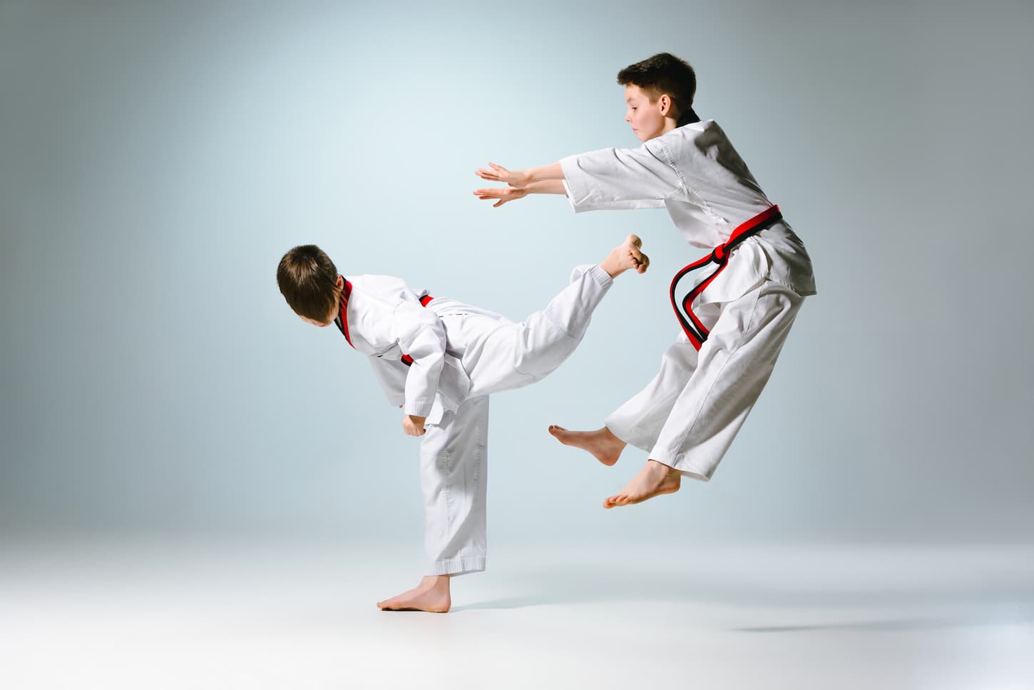 An image of a studio shot of two kids training karate martial arts.