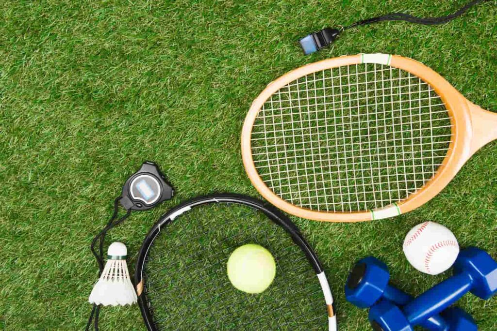 An image of a Top view of various sport equipment on green grass.