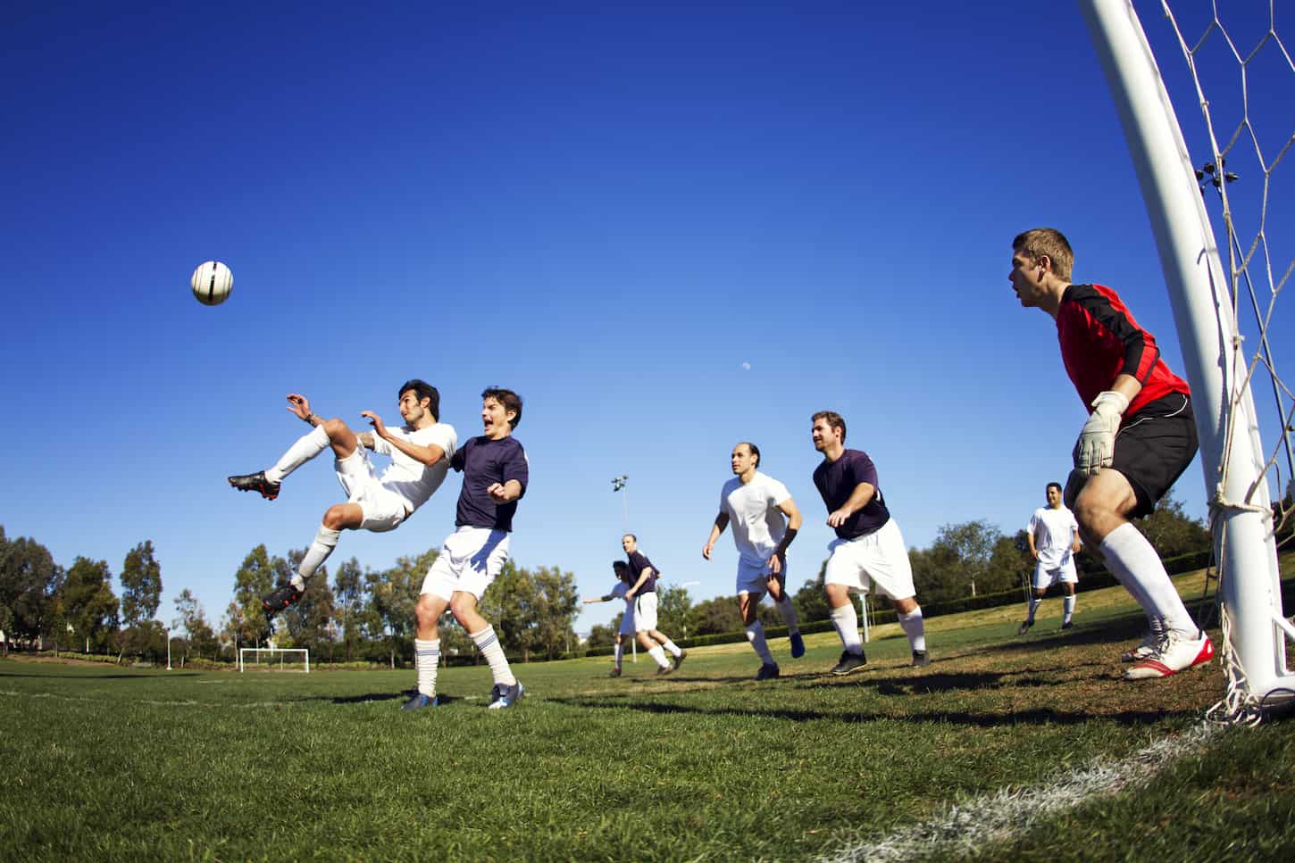An image of a group of boys Playing Soccer At Field.