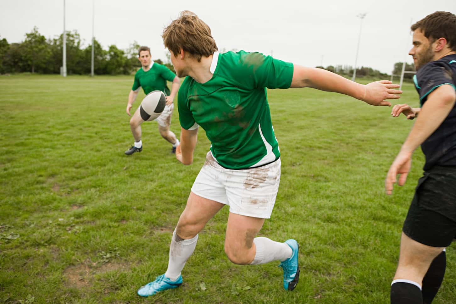 An image of gentlemen playing rugby game in the field.