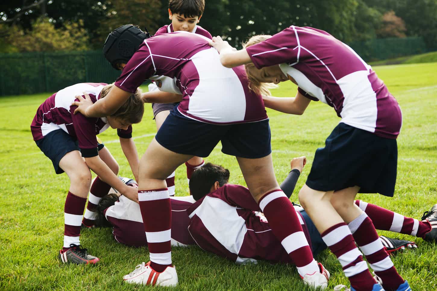 An image of Teenage schoolboy rugby team playing aggressively.