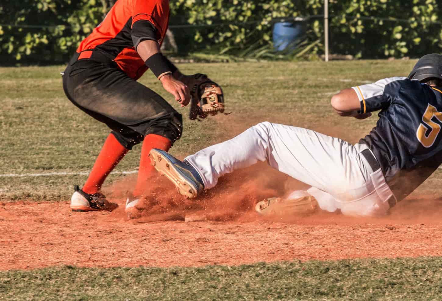 An image of a high school baseball game where a player is sliding into a base.
