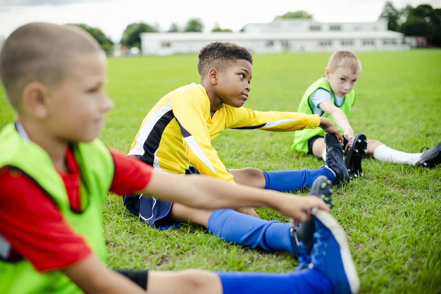 An image of Diverse kids stretching on the field.