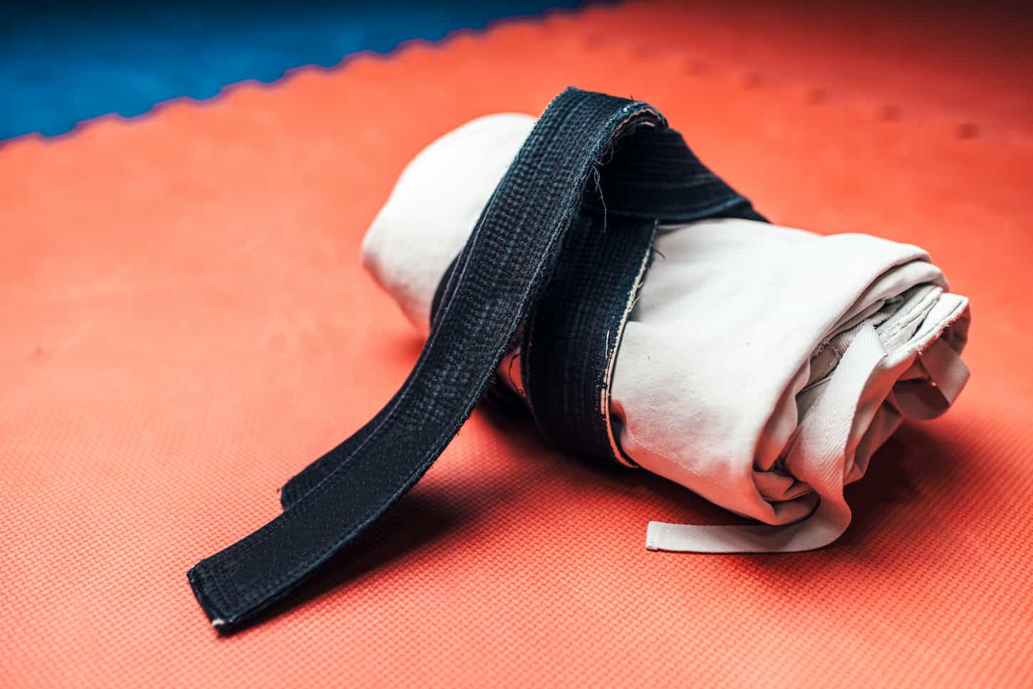 An image of Martial arts, white kimono, and black belt closeup.