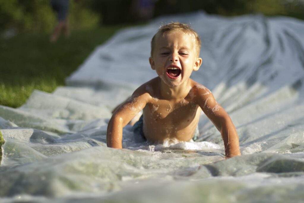 An image of a Boy On A Slip And Slide.