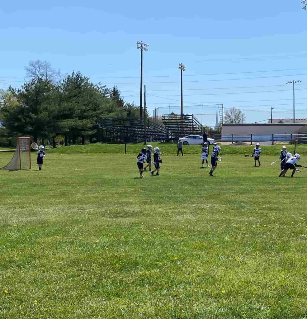 An image of a Boys' lacrosse game on a lacrosse field.