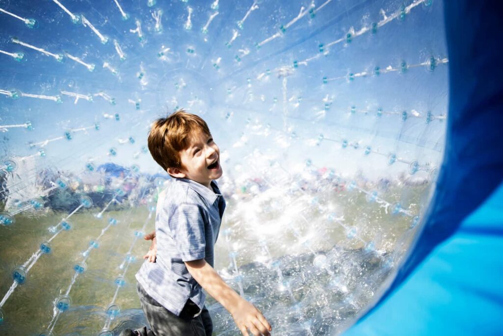 An image of a Cheerful Boy In a Zorb Ball.