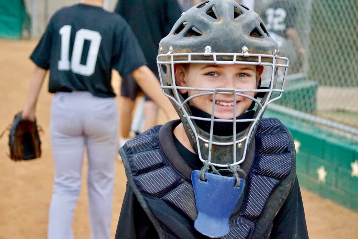 An image of An amazing, happy, and awesome kid, smiling after a baseball game.