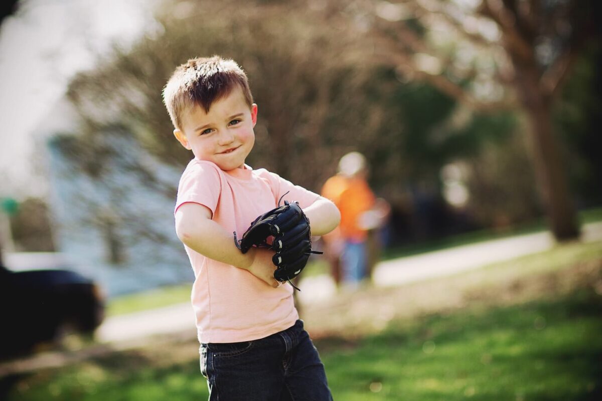 An image of a Little boy at home in the yard playing catch with baseball with dad.