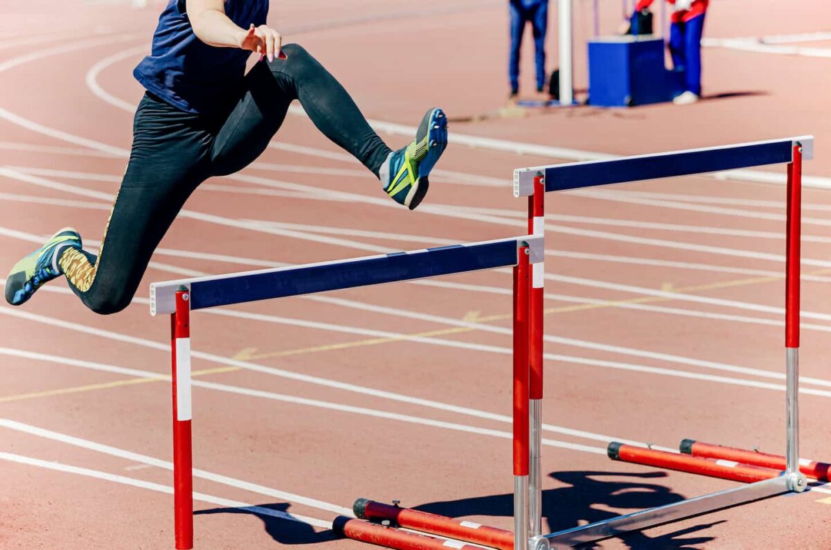 An image of a girl athlete running hurdles track and field races.