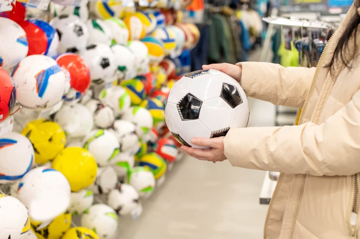 An image of an unidentified woman Choosing a soccer ball in the store.